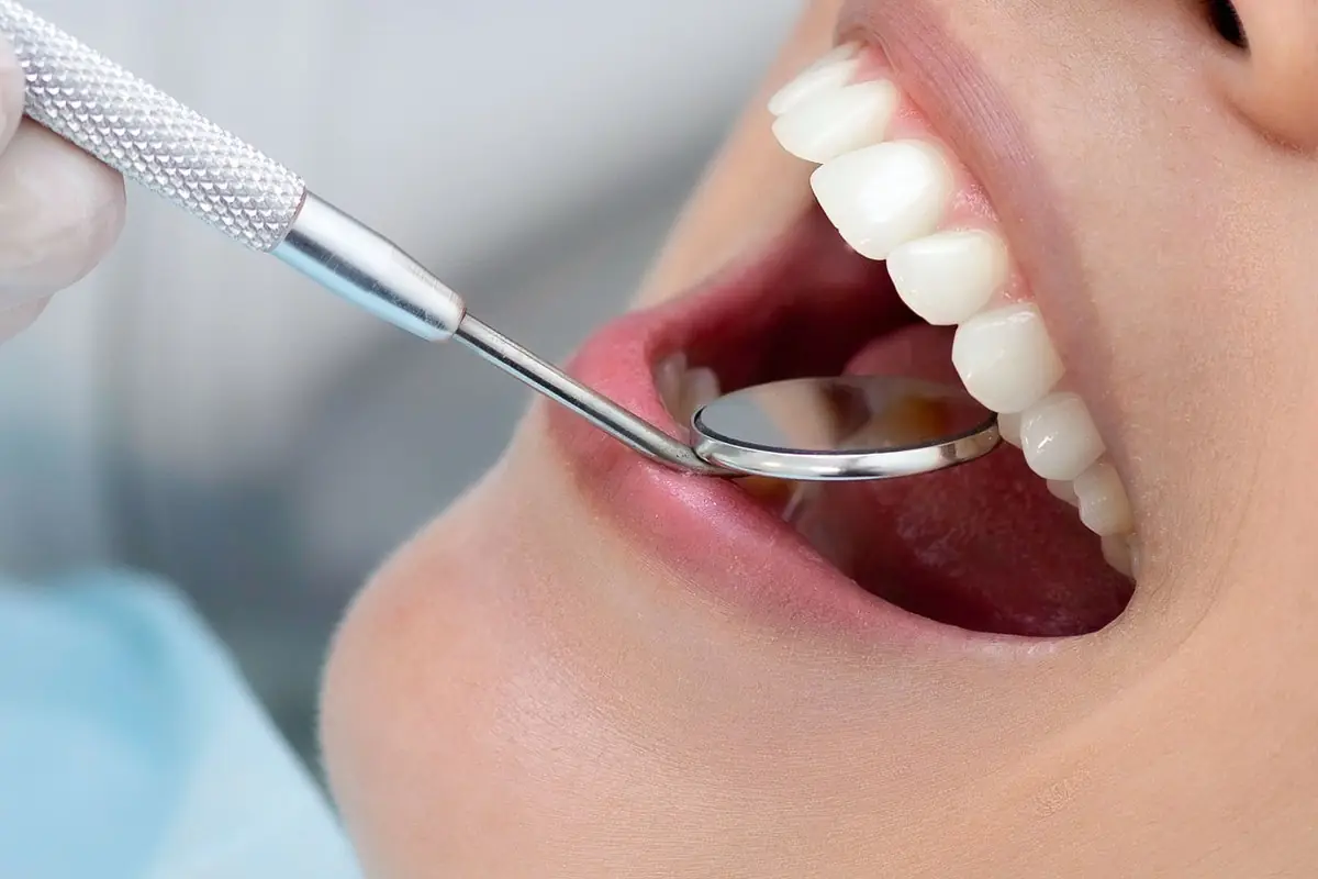 Dentist checking a patient's teeth with a mouth mirror