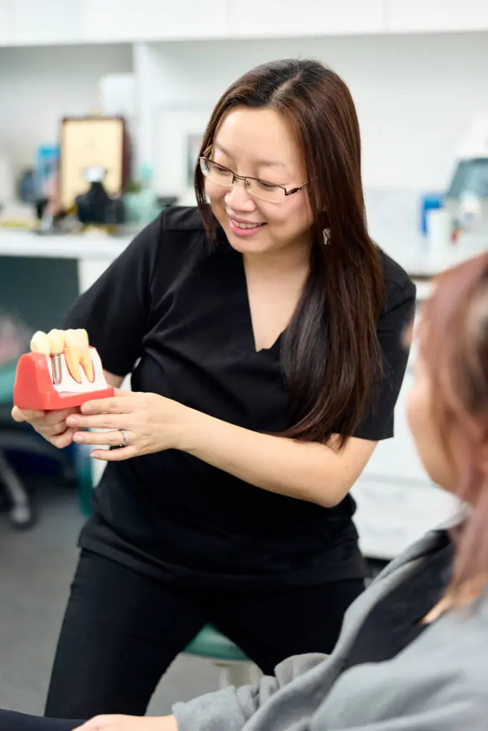 Dr Anna Chau explaining an implant model to a patient